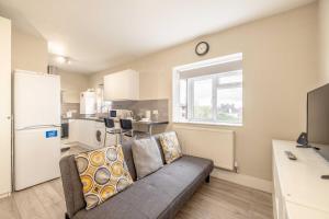 a living room with a couch and a kitchen at Cosy Heathrow Apartment - Free Parking in Colnbrook