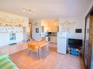 a kitchen with a table and chairs and a refrigerator at Villetta Cala Petralana in Porto Pollo