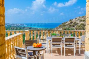 einen Tisch und Stühle auf einem Balkon mit Meerblick in der Unterkunft Aqua Royal in Peyia