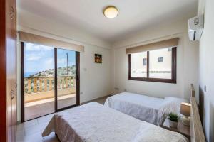 1 Schlafzimmer mit 2 Betten und einem großen Fenster in der Unterkunft Aqua Royal in Peyia