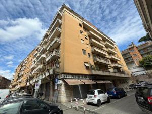 un edificio alto con macchine parcheggiate di fronte di Bellina Suite at the Vatican a Roma