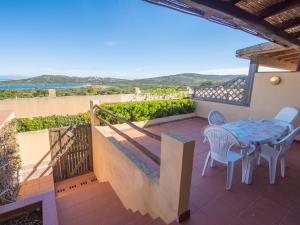 a balcony with a table and chairs and a view at Villetta Cala Petralana in Porto Pollo