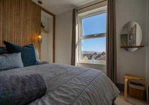 een slaapkamer met een groot bed en een raam bij Pebble Cottage - Sea Views, Free Parking & Dog Friendly in Wyke Regis