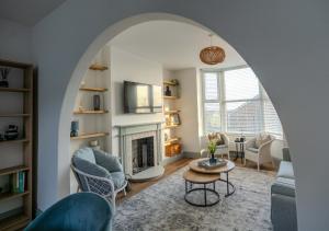 a living room with an archway with a fireplace at Pebble Cottage - Sea Views, Free Parking & Dog Friendly in Wyke Regis