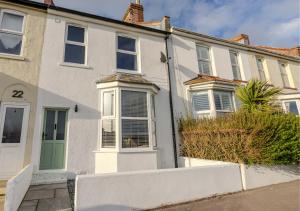 a white house with a green door at Pebble Cottage - Sea Views, Free Parking & Dog Friendly in Wyke Regis