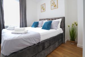 a bedroom with a large bed with white and blue pillows at DreamLand Apartment in Surčin
