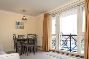 sala de estar con mesa y sillas y balcón en Aqua Marina - breathe in, relax en Pevensey