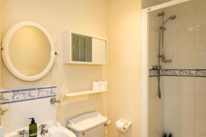 La salle de bains est pourvue de toilettes, d'un lavabo et d'un miroir. dans l'établissement Aqua Marina - breathe in, relax, à Pevensey