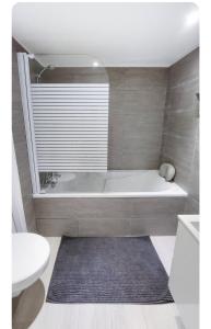 een badkamer met een bad, een toilet en een wastafel bij Les Garennes in Rillieux