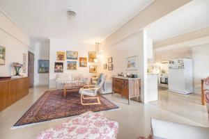 a living room with a table and chairs and a kitchen at Family Apt in Glyfada-Kyprou, by Comfortbnb in Athens