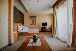 a bedroom with a bed and a table with a vase on it at Bed and Breakfast Kovačević in Irig