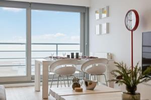 comedor con mesa y sillas y ventana grande en Apartment with frontal sea view in Knokke, en Knokke-Heist