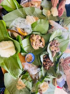 a bunch of food on a bunch of leaves at Wooden floor house Ngọc trinh Homestay in Bản Qua