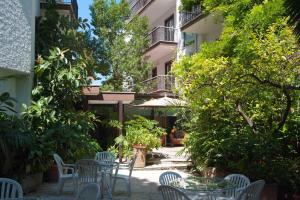 cortile con sedie, tavoli e alberi di Hotel La Pergola a Roma