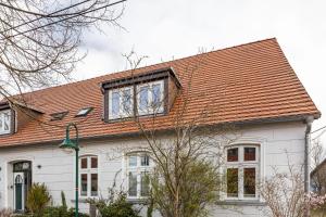 a white house with an orange roof at Storchenhorst 6 in Buchholz