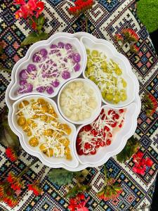 a group of four dishes filled with different colored foods at Wooden floor house Ngọc trinh Homestay in Bản Qua