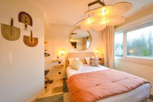 een slaapkamer met een bed met een spiegel en een raam bij Hotel Classe Troyes - La Chapelle Saint Luc in La Chapelle-Saint-Luc