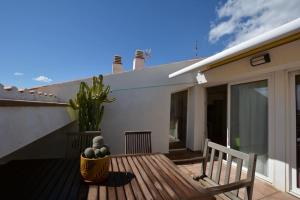 a wooden deck with a bench and a plant on a house at Private and charming apartment in front of the sea in Altafulla