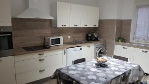 uma pequena cozinha com uma mesa e um micro-ondas em maison plages et calanques 4/6 personnes em Marselha