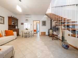 a living room with a couch and a staircase at Maria Grazia's Holiday Home in Massama