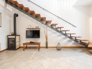 a living room with a staircase and a tv at Maria Grazia's Holiday Home in Massama