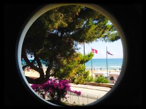 a round window with a view of the beach at Hotel Vela Velo Club Vieste in Vieste