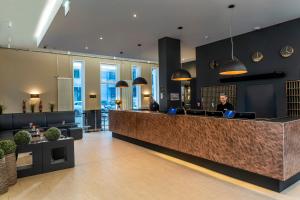 a man sitting at a counter in a lobby at Best Western Hotel am Spittelmarkt in Berlin