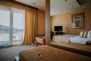 a hotel room with two beds and a balcony at Bed and Breakfast Kovačević in Irig