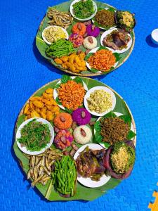 two plates of different types of food on a table at Wooden floor house Ngọc trinh Homestay in Bản Qua