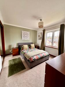 a bedroom with a bed and a window at Apartment with parking, close to the Raigmore hospital in Inverness