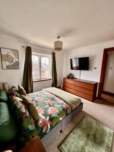a bedroom with a bed and a flat screen tv at Apartment with parking, close to the Raigmore hospital in Inverness