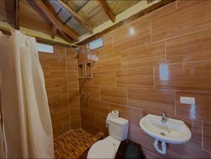 a bathroom with a toilet and a sink at Hotel Palma Coco in Ayampe