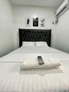 un mando a distancia sentado sobre una cama en Unique apartment en Mombasa