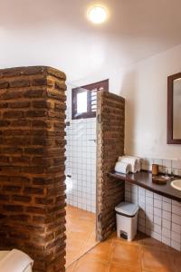 ein Badezimmer mit einer Backsteinwand neben einem Waschbecken in der Unterkunft Duro Beach Hotel in Cumbuco