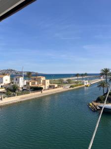 een rivier met een boot in het naast een strand bij APPARTEMENT VUE MER Empuriabrava in Empuriabrava