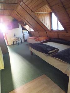 een kamer met 2 bedden op een zolder bij Gaz69 vendégház in Szilvásvárad