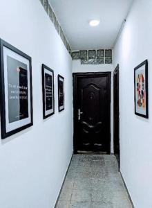 a hallway with a black door and pictures on the walls at Cozy Studio room, Wi-Fi & Smart TV in Lagos