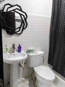 a bathroom with a toilet and a sink at Cozy Studio room, Wi-Fi & Smart TV in Lagos