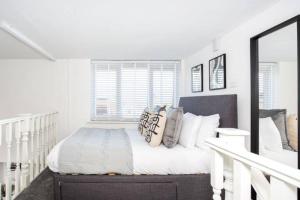 a white bedroom with a bed with pillows at Loft Style Apartment w/ Parking, in Leigh-on-Sea in Southend-on-Sea