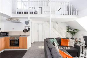 een woonkamer met een bank en een keuken bij Loft Style Apartment w/ Parking, in Leigh-on-Sea in Southend-on-Sea