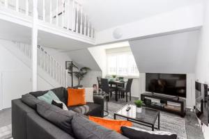 a living room with a couch and a table at Loft Style Apartment w/ Parking, in Leigh-on-Sea in Southend-on-Sea
