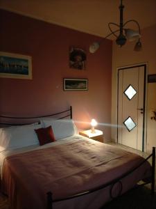 um quarto com uma cama grande com um candeeiro e uma porta em Sleep In Sicily em Siracusa