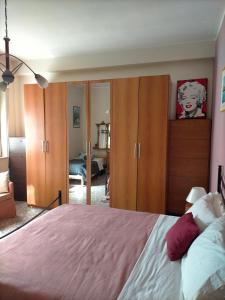 1 dormitorio con 1 cama y armarios de madera en Sleep In Sicily, en Siracusa