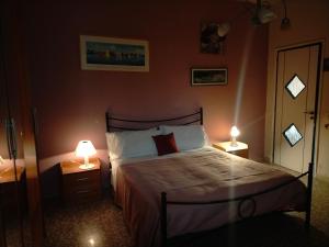 um quarto com uma cama e 2 candeeiros nas mesas em Sleep In Sicily em Siracusa
