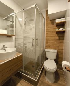 a bathroom with a toilet and a glass shower at Hotel Inti - Llanka in Iquique
