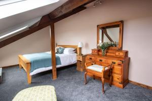 um quarto com uma cama, uma cómoda e um espelho em Fern Cottage at Hewish Mill em Bittadon