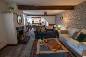 uma sala de estar com um sofá e uma mesa em Fern Cottage at Hewish Mill em Bittadon