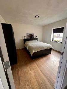 1 dormitorio con 1 cama y suelo de madera en Luxe recreatiewoning midden in bosrijke omgeving en Waalre