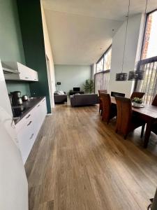 a kitchen and living room with a table and chairs at Luxe recreatiewoning midden in bosrijke omgeving in Waalre