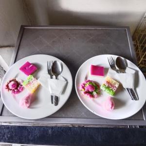dos platos de postres en una bandeja con tenedores y cucharas en Bali jungle cabin, en Jatiluwih
